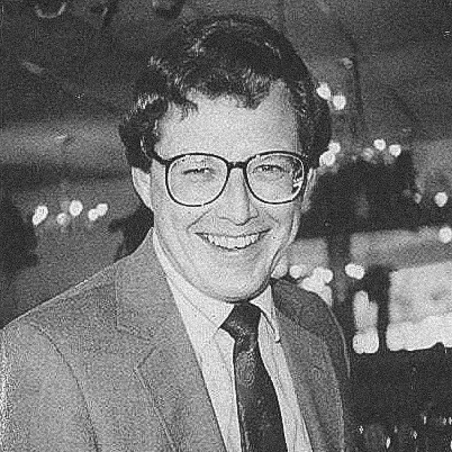 James Michael Lewek in a suit smiling.